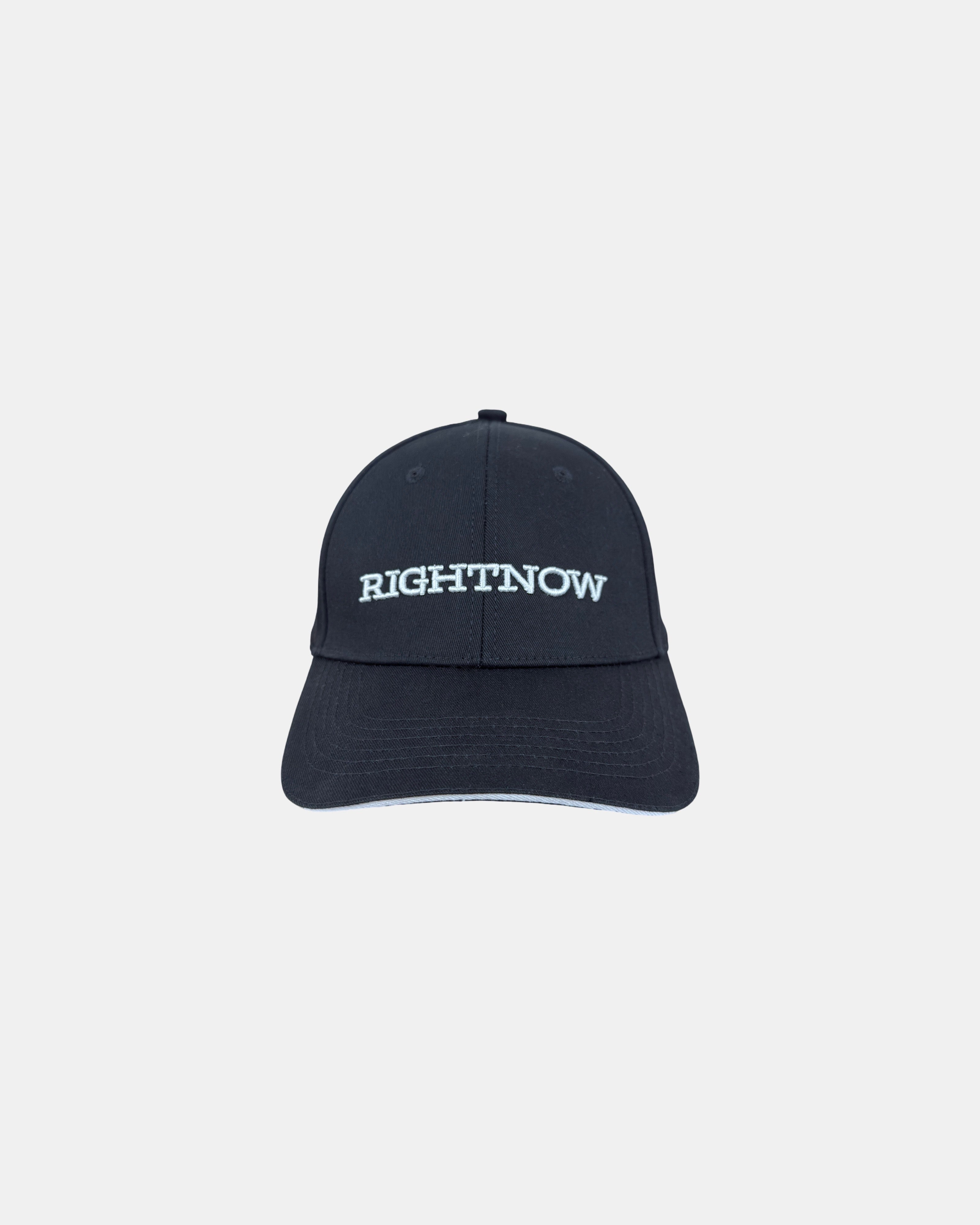 Front view of a matt black minimalist baseball cap featuring the ‘RIGHTNOW’ logo in white embroidery for simple, everyday style.
