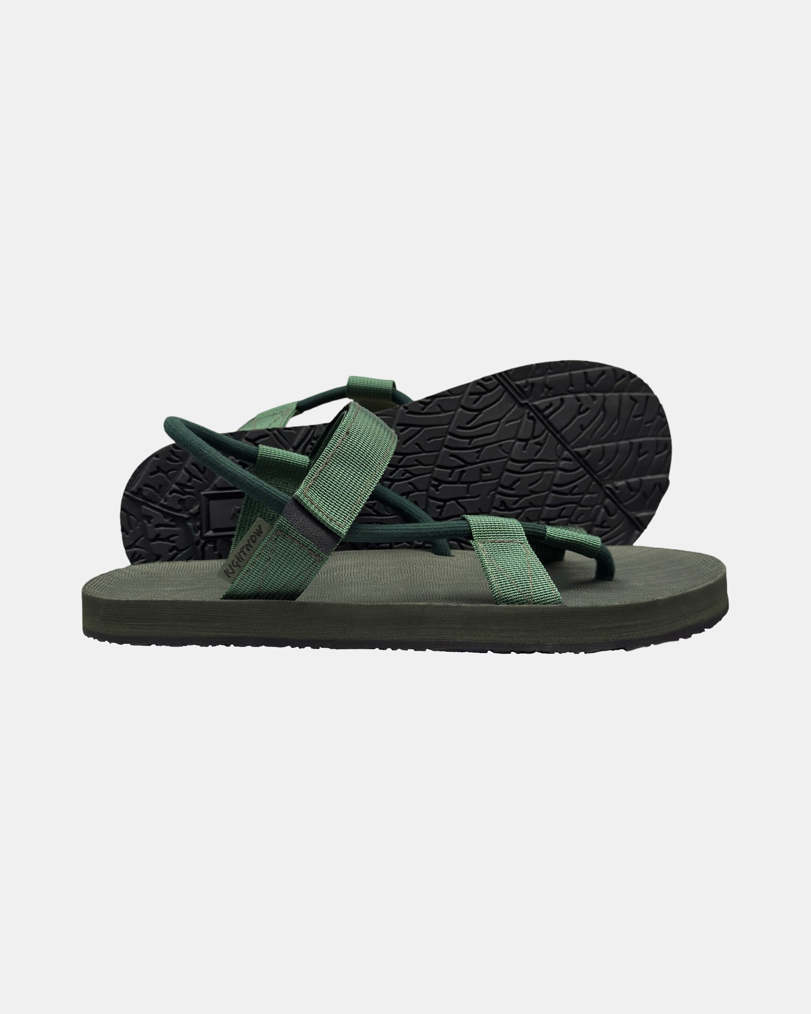 Men's forest-tone minimalist sandal with flexible strap and an open-toe design, with the black rubber textured anti-slip sole behind it.