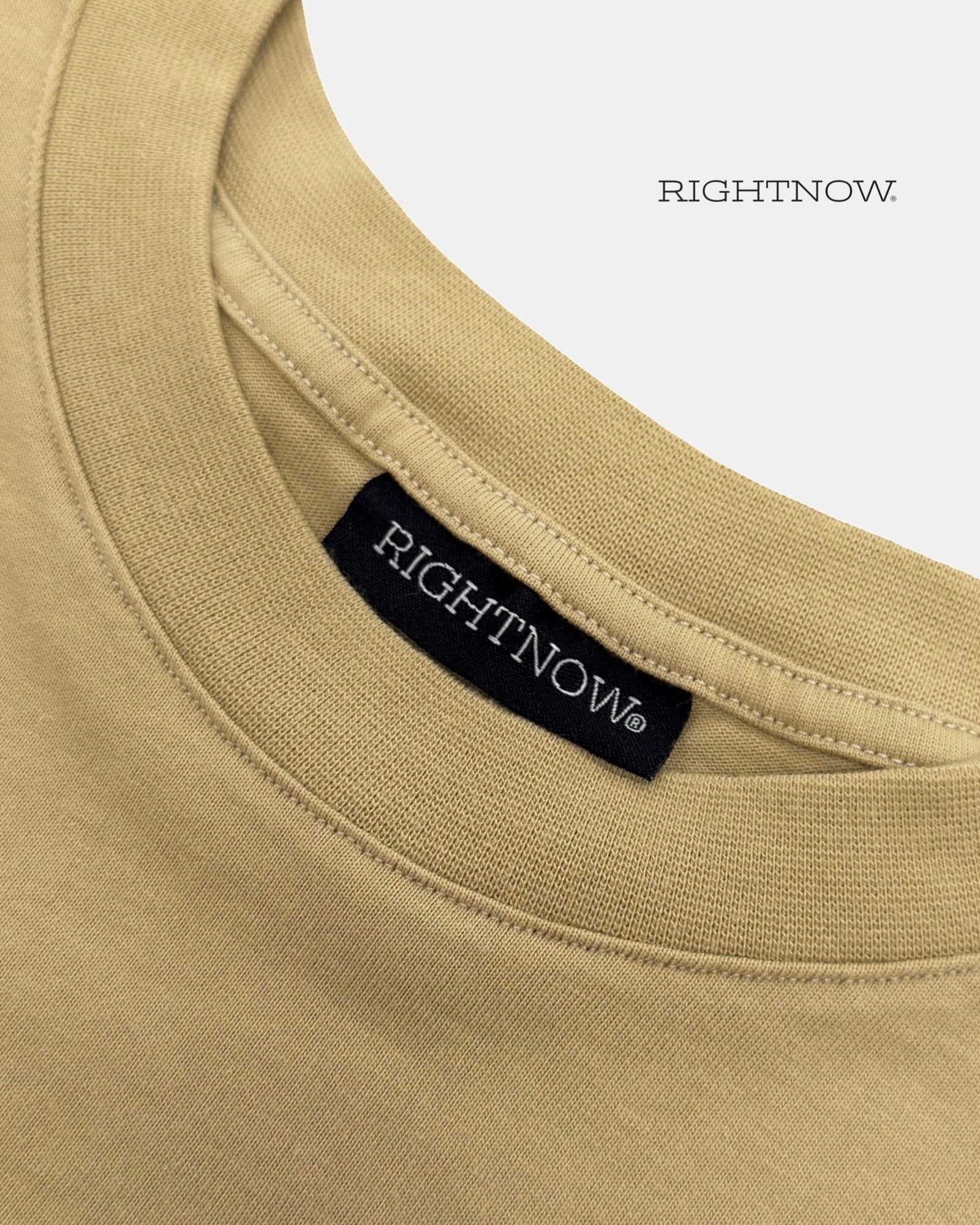 Brand logo label sewn on the back of the collar of a sand beige Moment cotton oversized t-shirt.