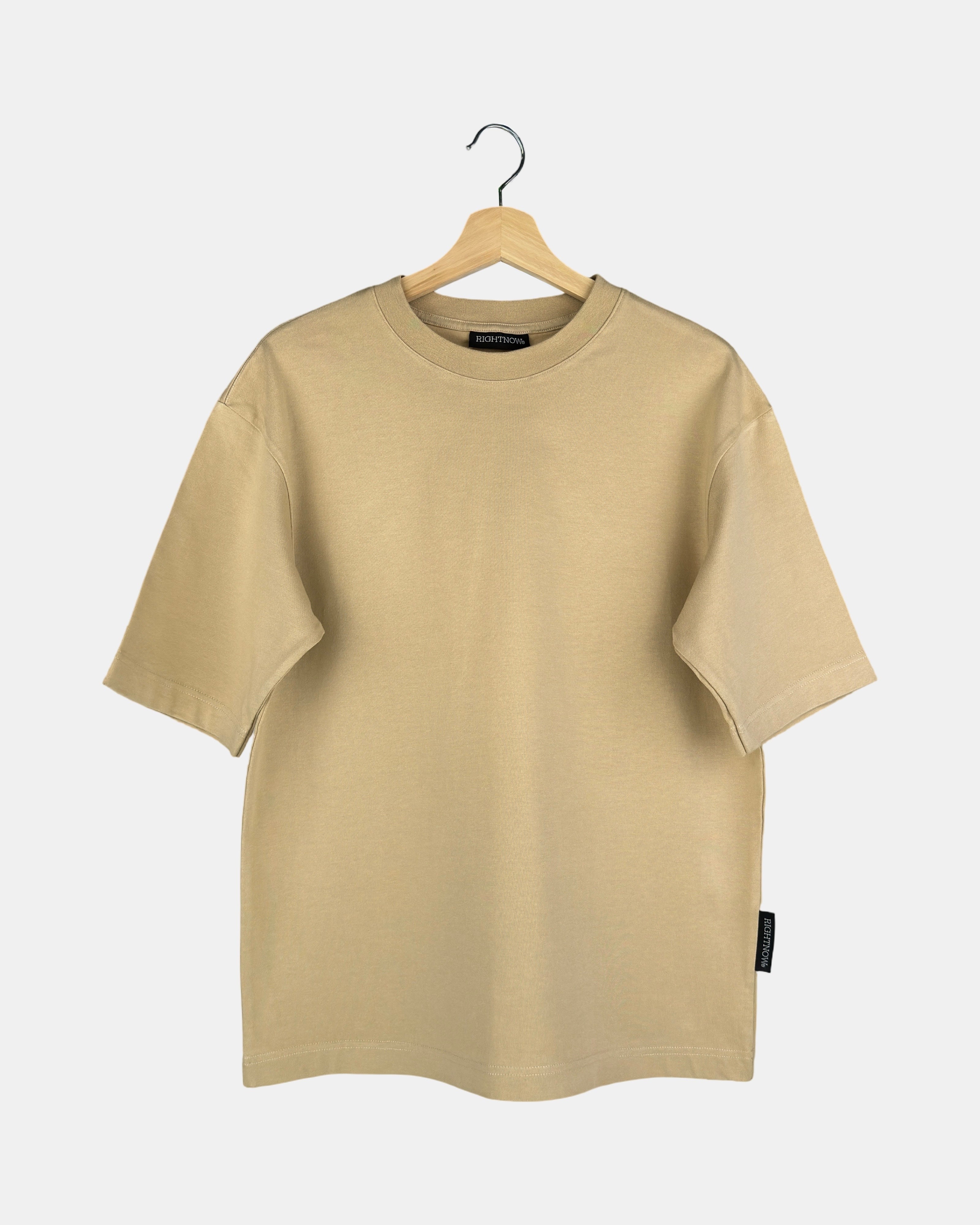 Unisex Moment oversized plain t-shirt in sand beige, made from premium cotton, shown from the front to feature its butterfly-knitted crewneck collar on a hanger.