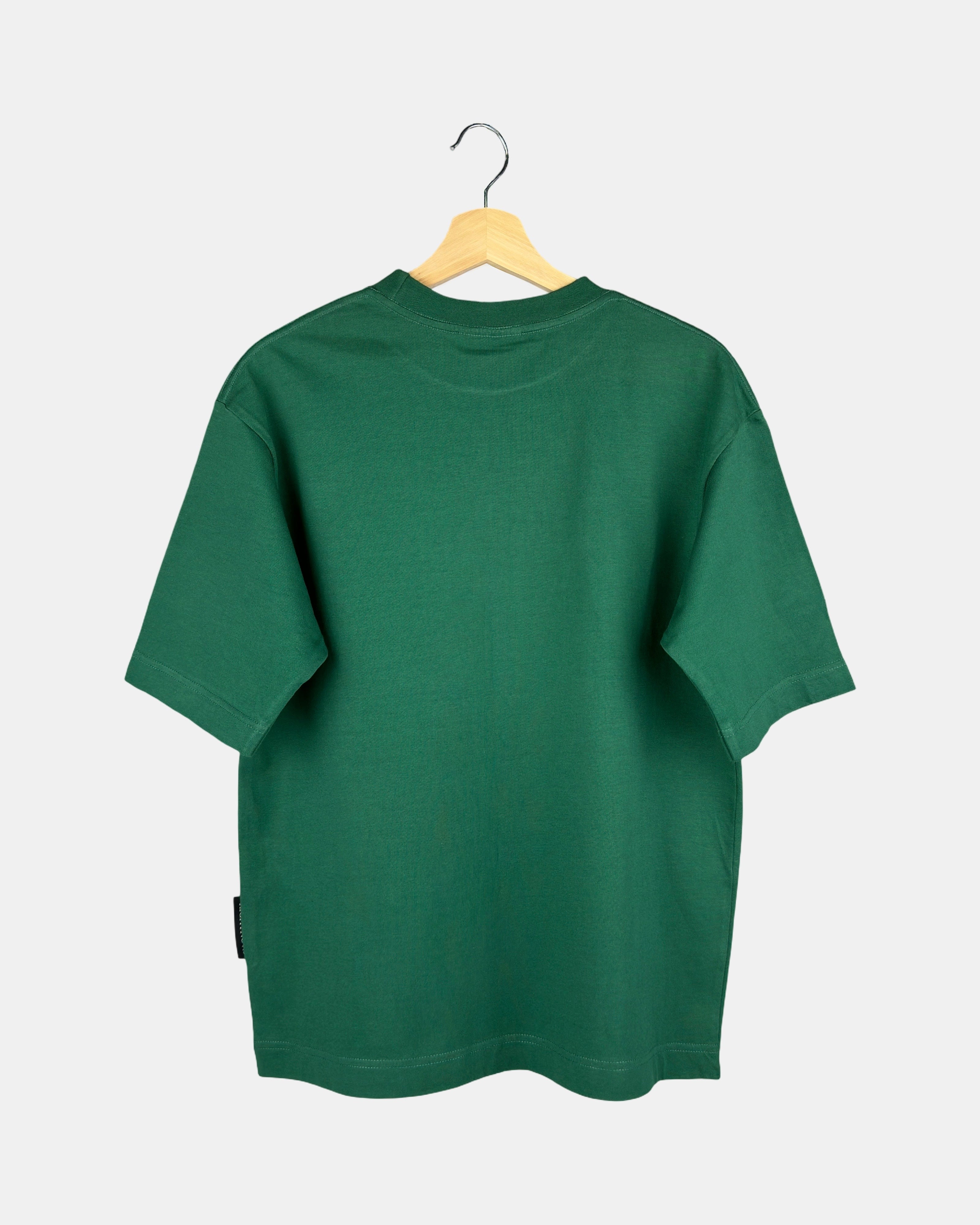The back view of a unisex Moment oversized plain t-shirt in natural green, showing the clean design and drape of the premium cotton fabric on a hanger.