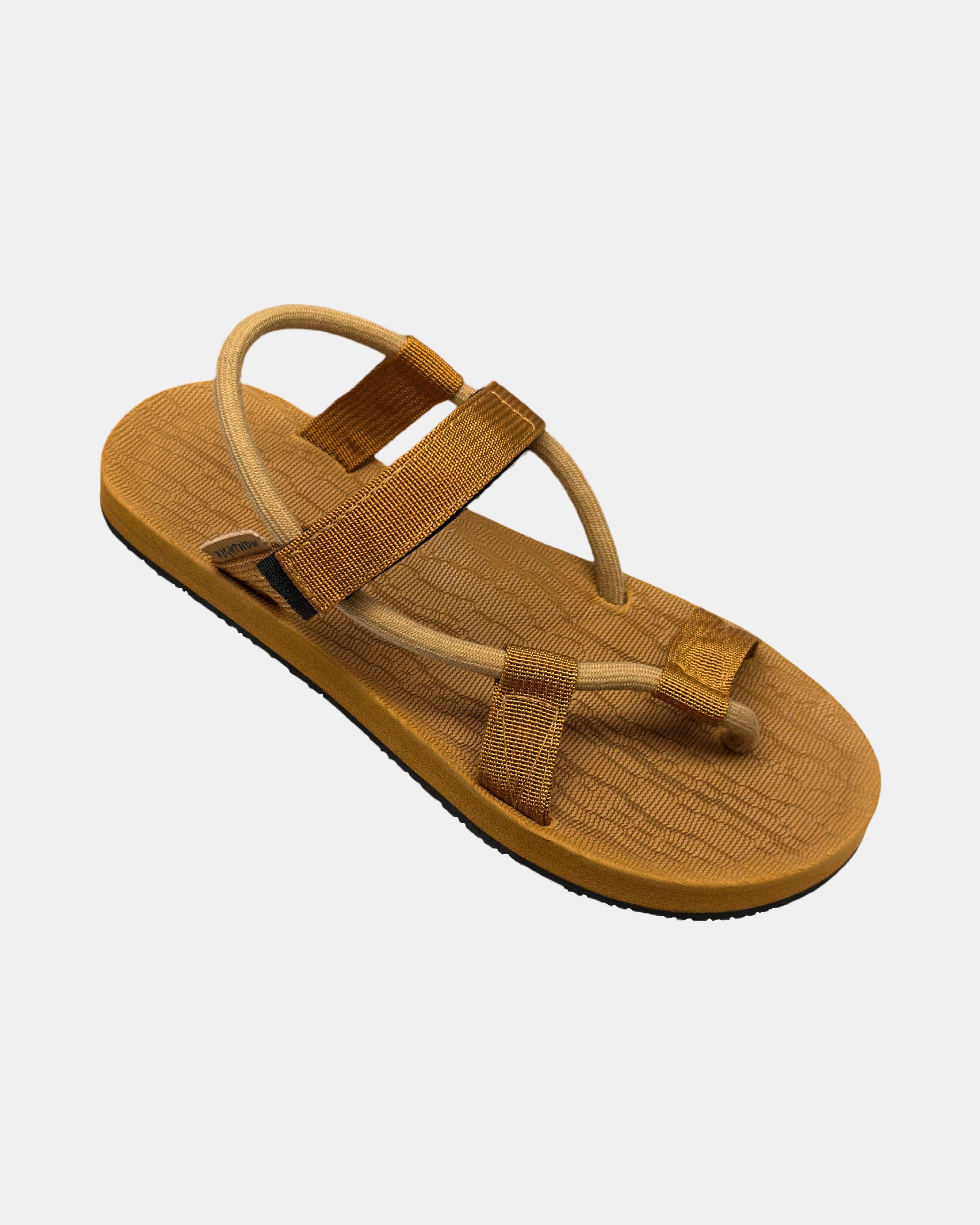 A 45-degree angled view of a women's earth brown rubber Roman-style sandal with a single 360° flexible strap around the ankle.