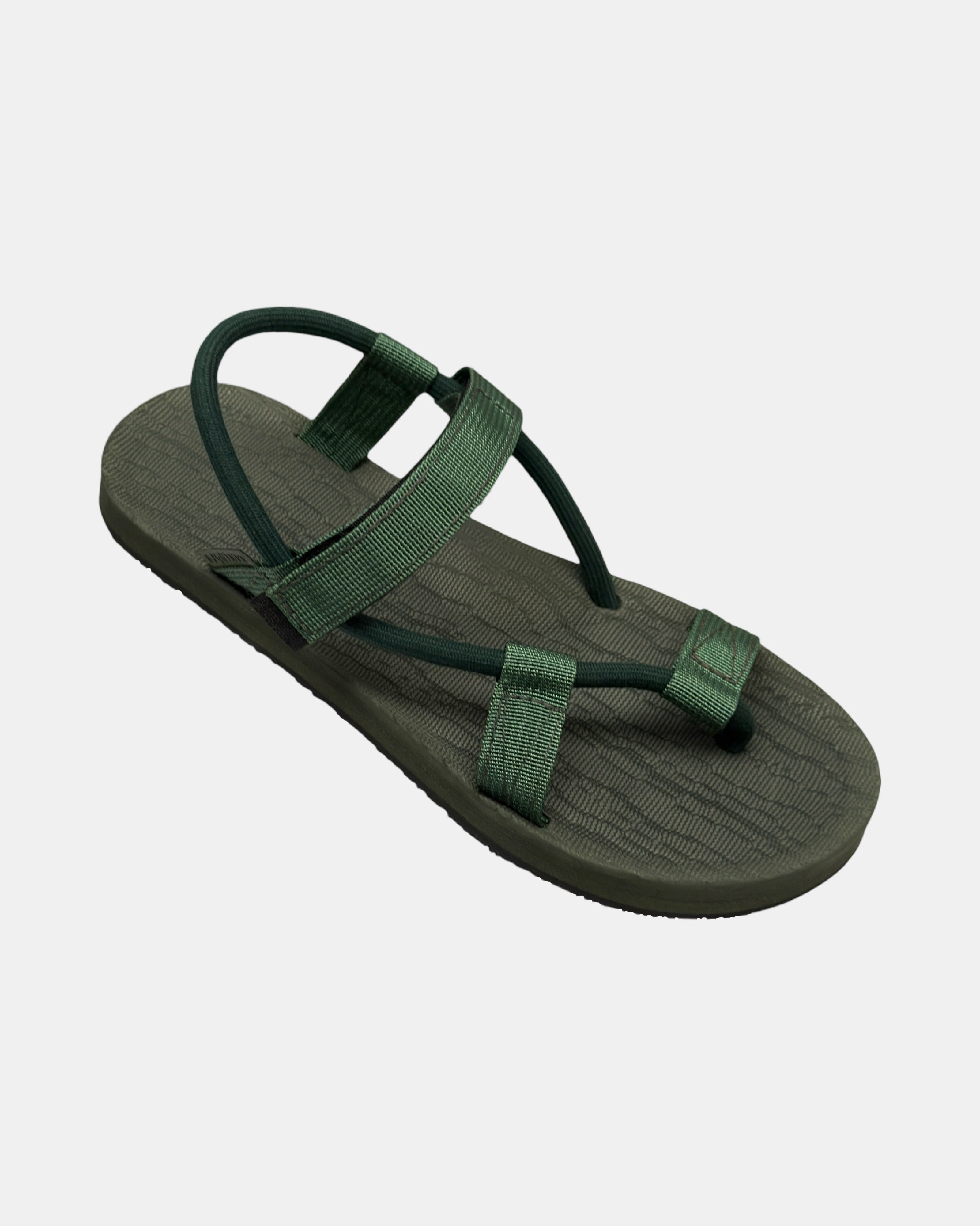 A 45-degree angled view of a women's natural green rubber Roman-style sandal with a single 360° flexible strap around the ankle.