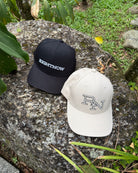 Minimalist RIGHTNOW Ignite caps in both sand beige and matt black, shown together on a natural rock, representing simple, authentic style for everyone.