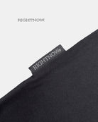 Brand logo label sewn on the outside of a matt black Moment cotton oversized plain t-shirt.