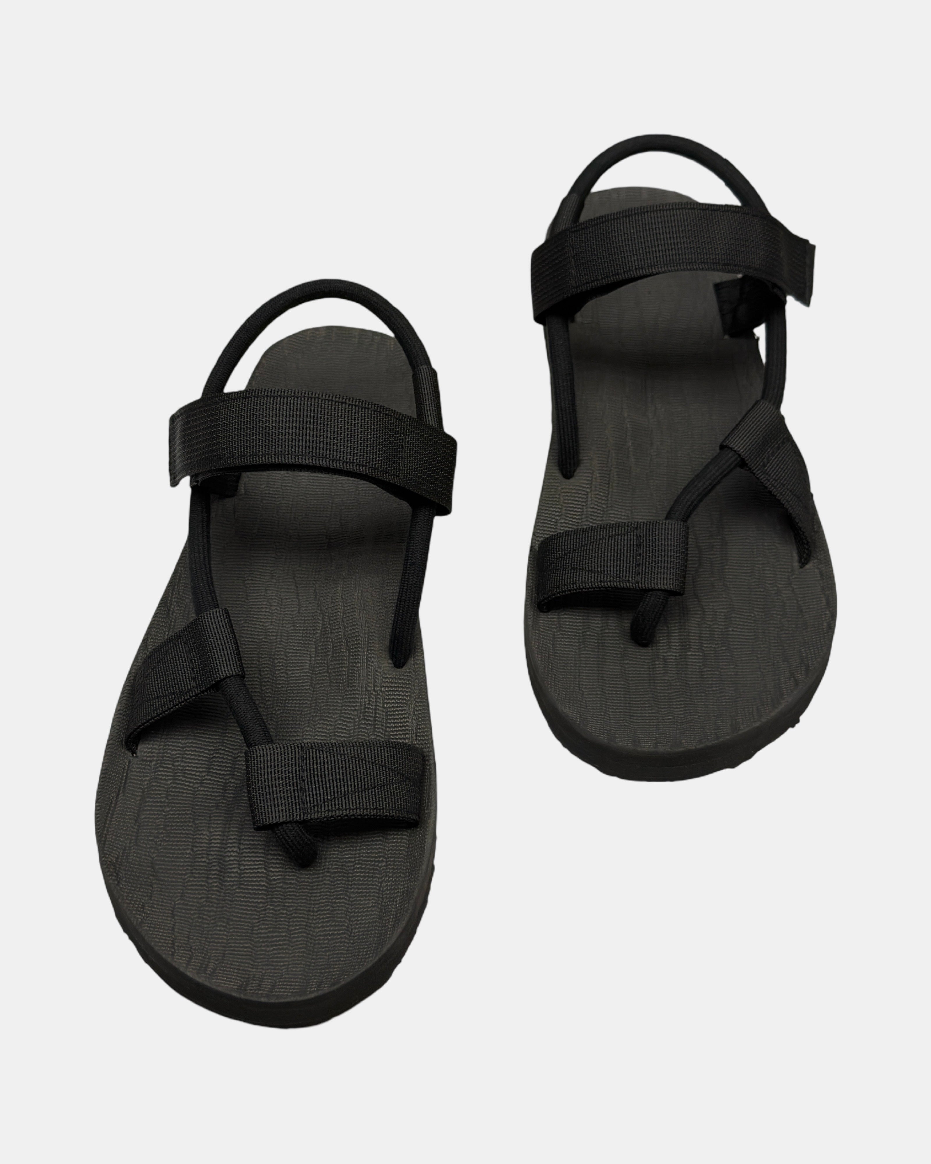 Front view of a pair of matt black rubber men's roman sandal with open-toe design and adjustable ankle strap.