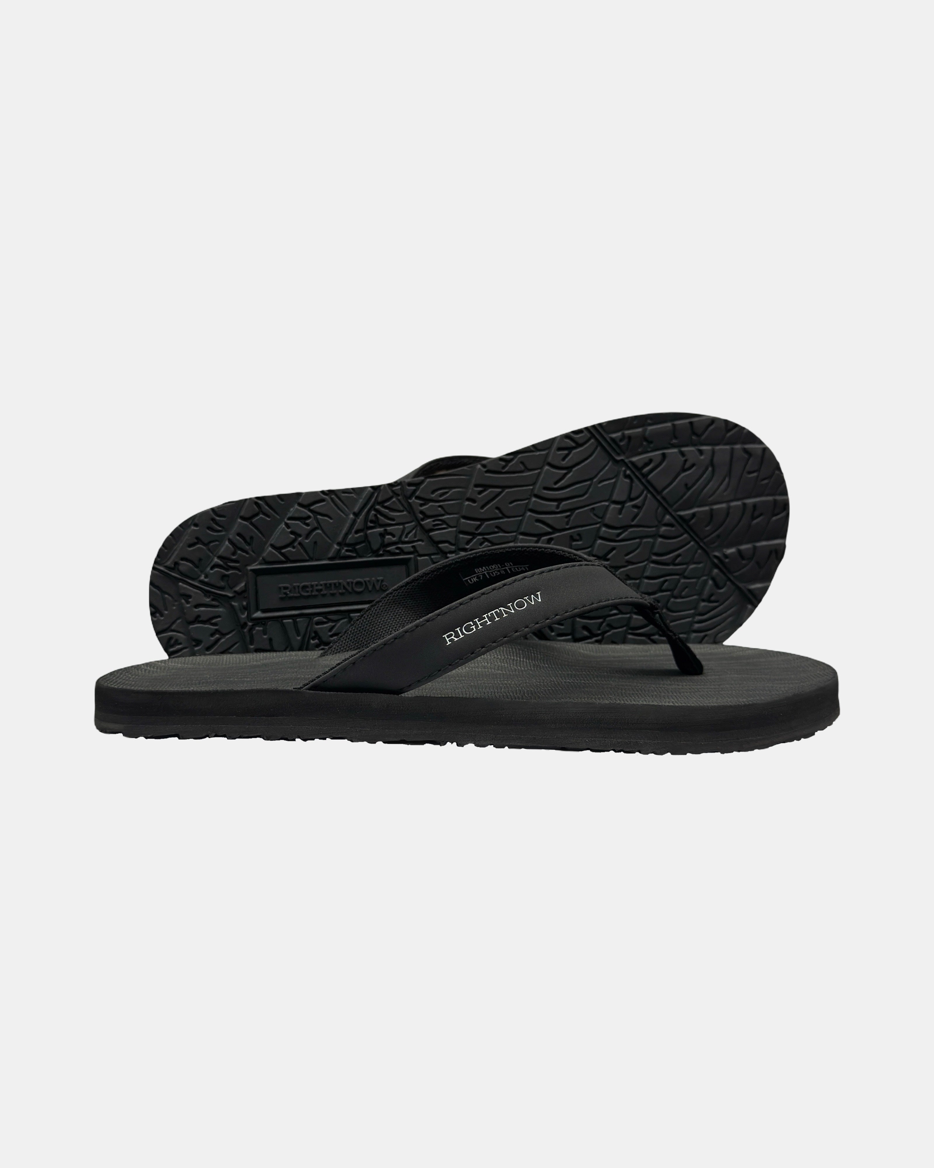 Men's elegant-tone minimalist thong sandal with V-shaped strap and an open-toe design, with the black rubber textured anti-slip sole behind it.