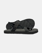 Men's elegant-tone minimalist sandal with flexible strap and an open-toe design, with the black rubber textured anti-slip sole behind it.