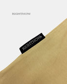 Brand logo label sewn on the outside of a sand beige Moment cotton oversized plain t-shirt.