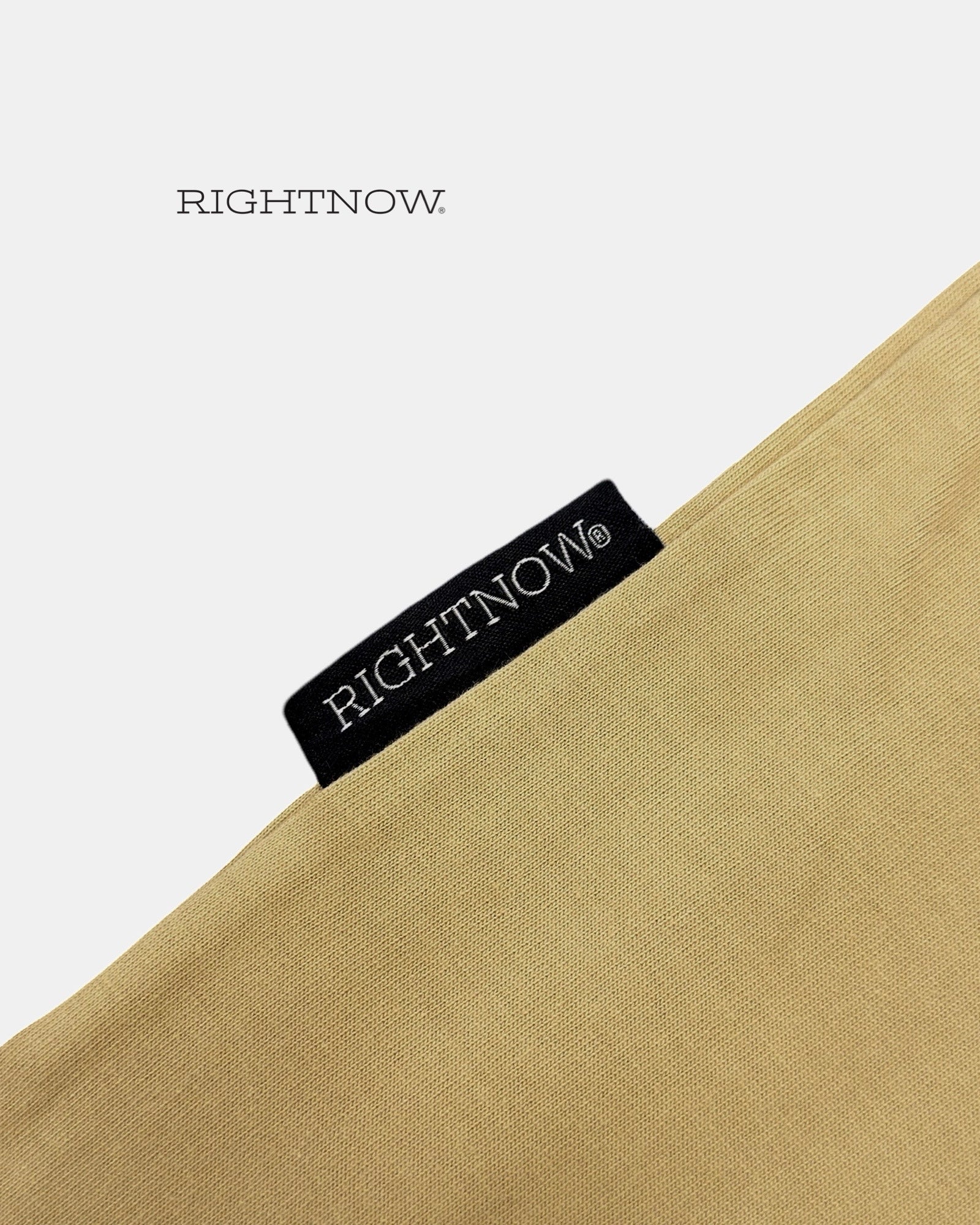 Brand logo label sewn on the outside of a sand beige Moment cotton oversized plain t-shirt.