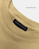 Brand logo label sewn on the back of the collar of a sand beige Moment cotton oversized t-shirt.