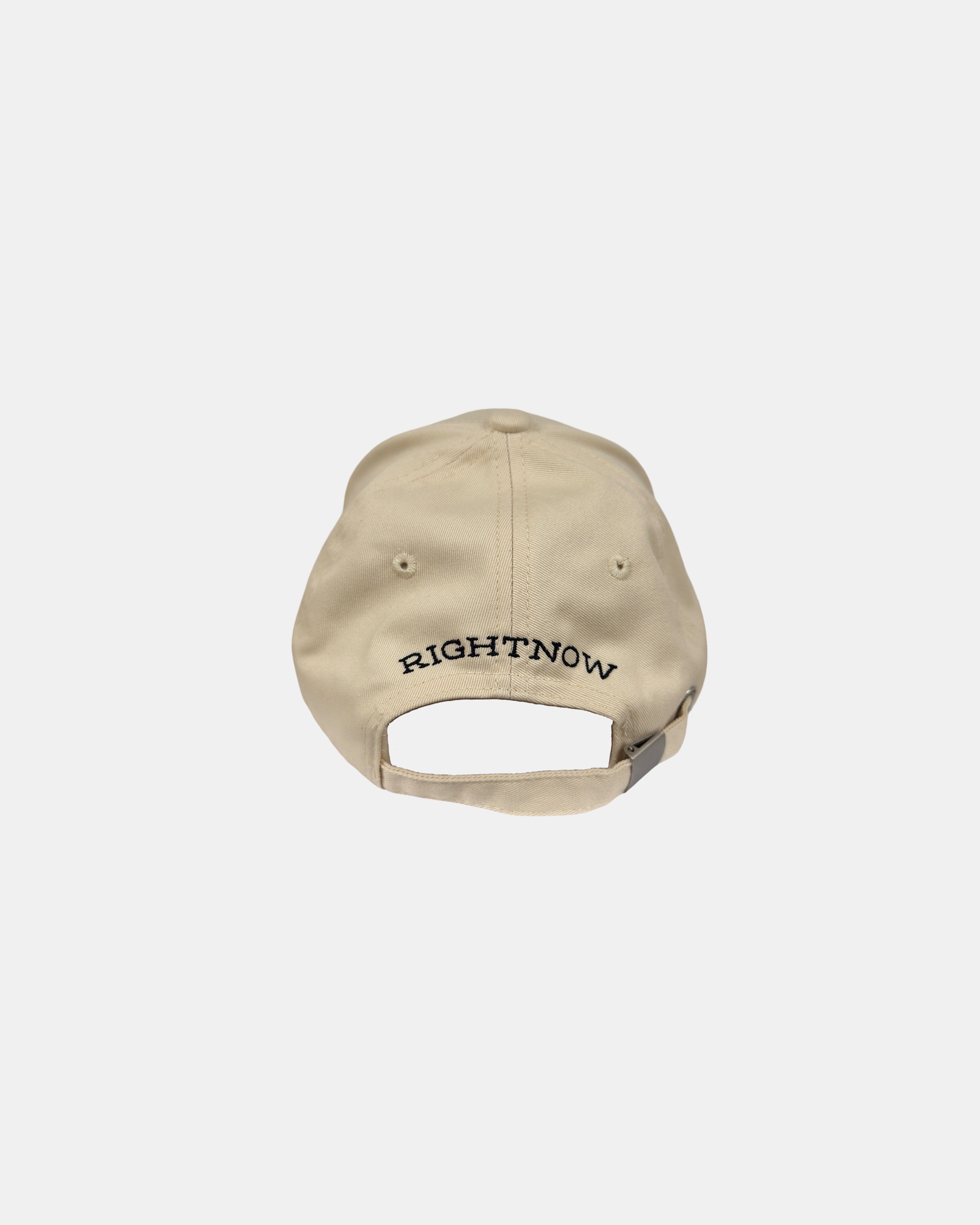 Back view of the sand beige Ignite cotton cap, showing the full ‘RIGHTNOW’ brand logo embroidery and the minimalist adjustable metal buckle.