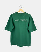 Back view of a unisex, natural green, cotton, oversized RIGHTNOW logo t-shirt with the brand name printed in large letters across the upper back.