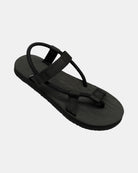 A 45-degree angled view of a women's matt black rubber Roman-style sandal with a single 360° flexible strap around the ankle.