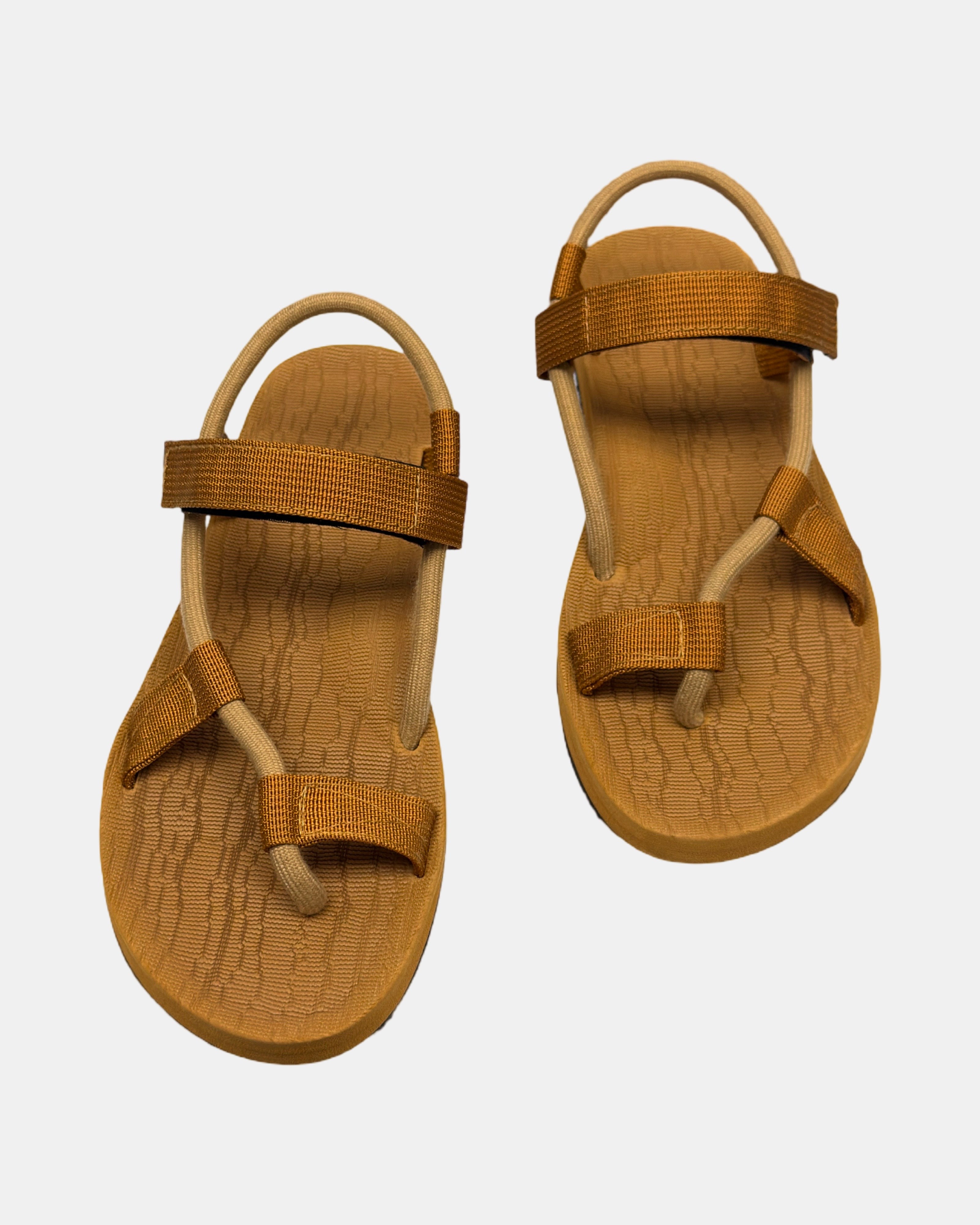 Front view of a pair of earth brown rubber women’s roman sandal with open-toe design and adjustable ankle strap.